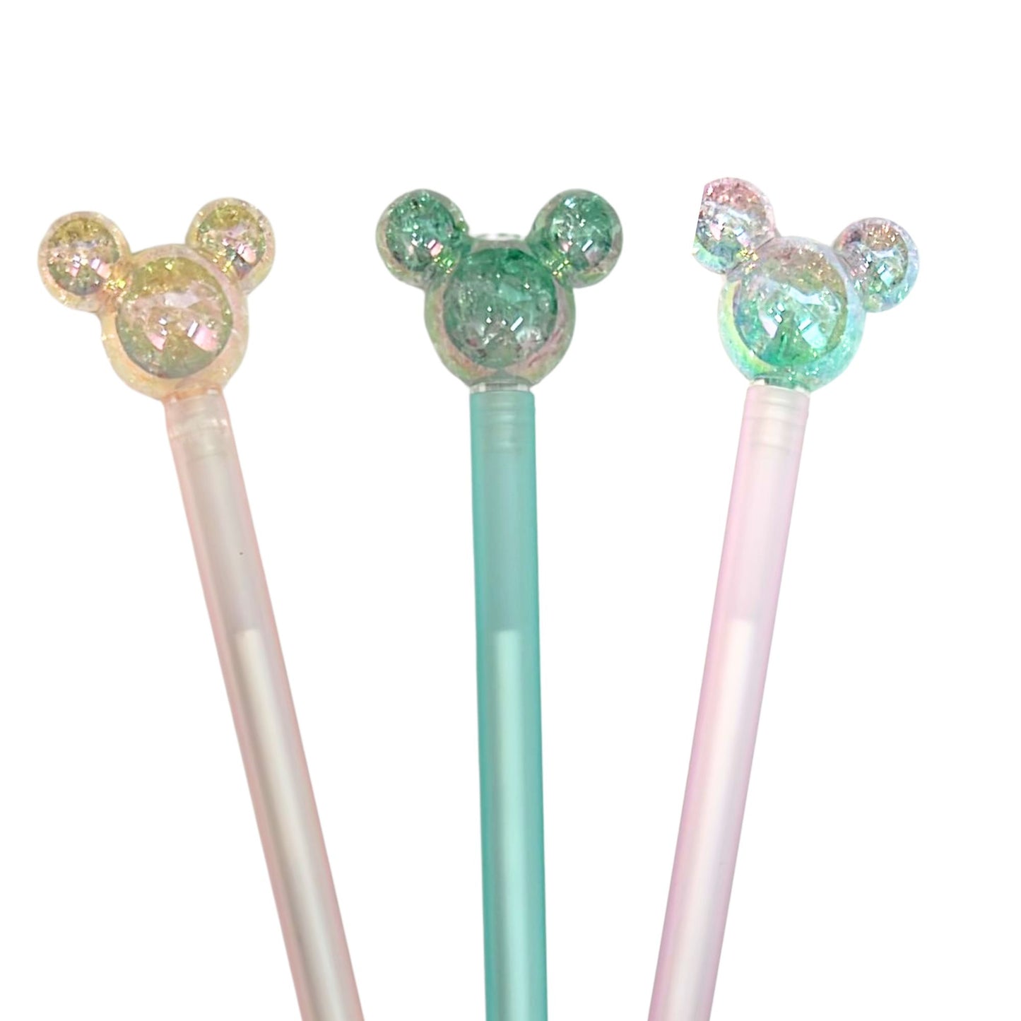 Three decorative pens with colorful, sparkly tops on a white background
