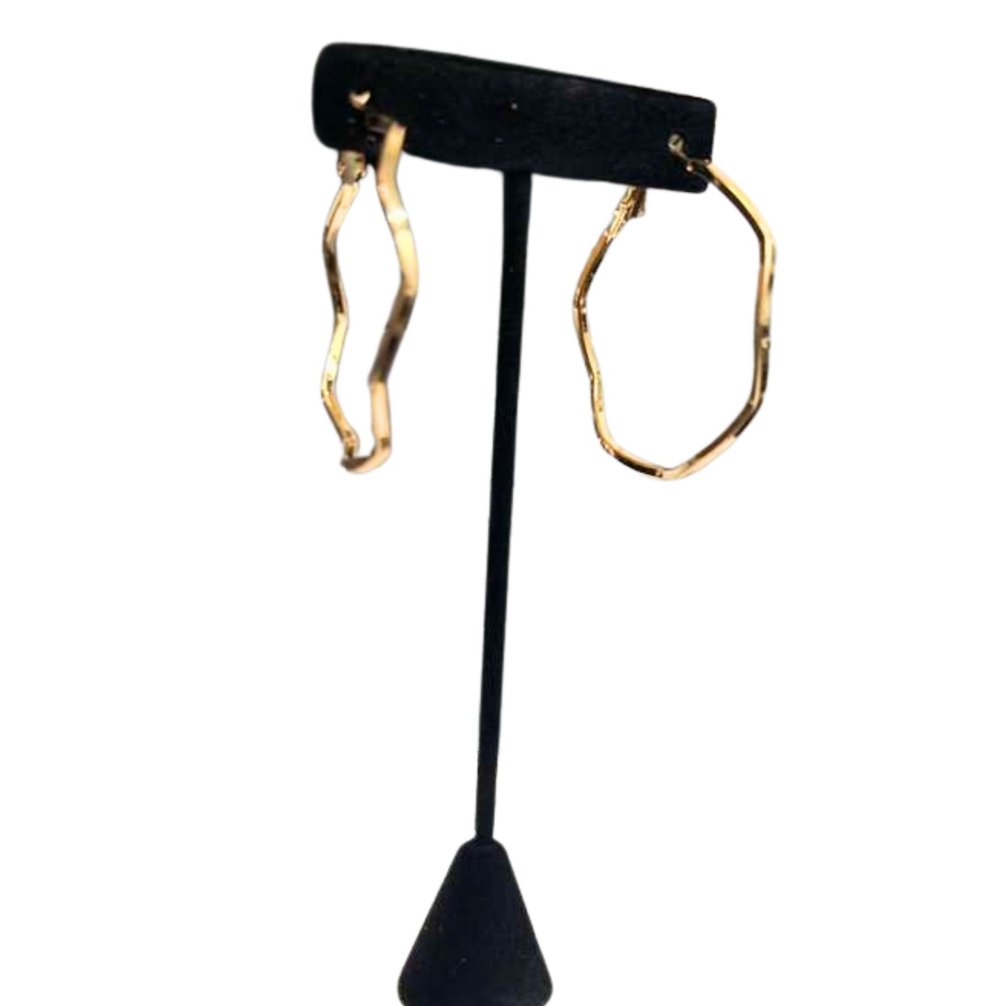 Gold hoop earrings on a black earring stand against a white background