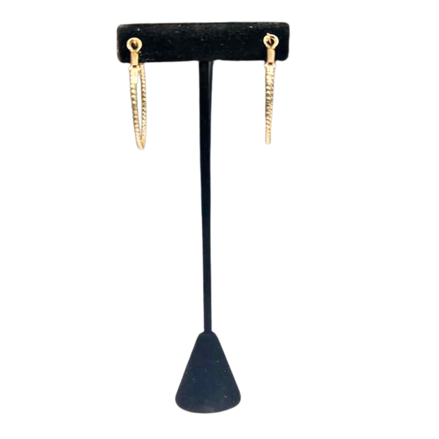 Gold hoop earrings on a black earring stand against a white background