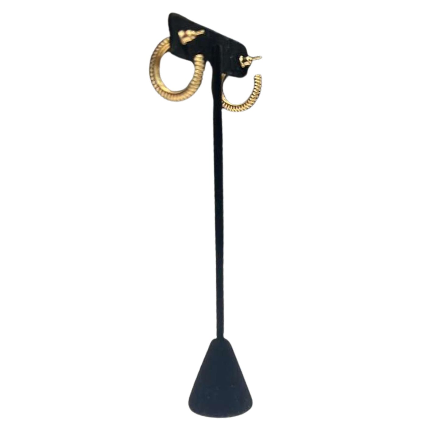 Gold hoop earrings on a black stand against a white background