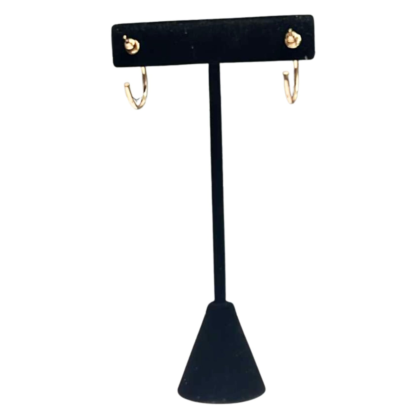 Black velvet earring stand with gold earrings on a white background
