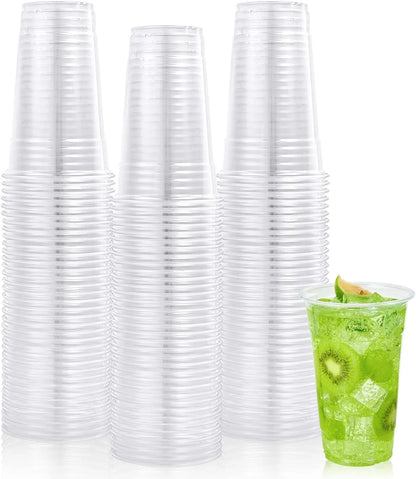 Stacks of clear plastic cups with a green drink in a cup on a white background