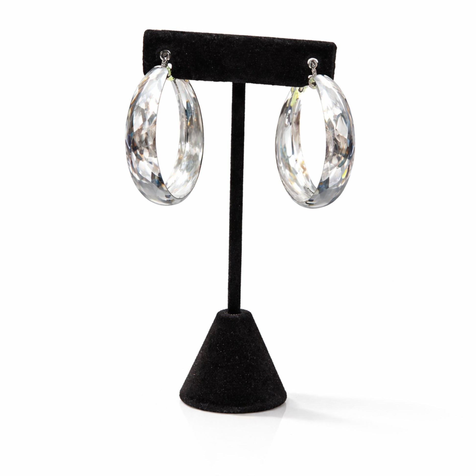 Clear hoop earrings on a black earring stand against a white background