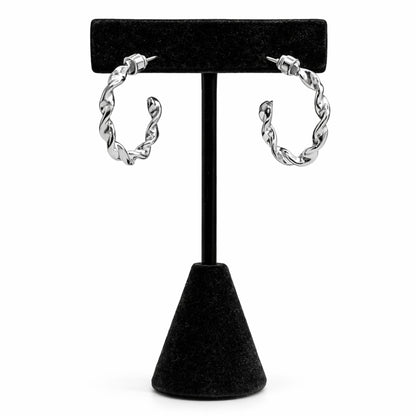 Pair of silver hoop earrings on a black stand against a white background