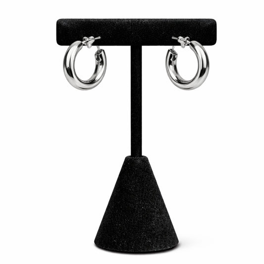 Silver hoop earrings on a black stand against a white background