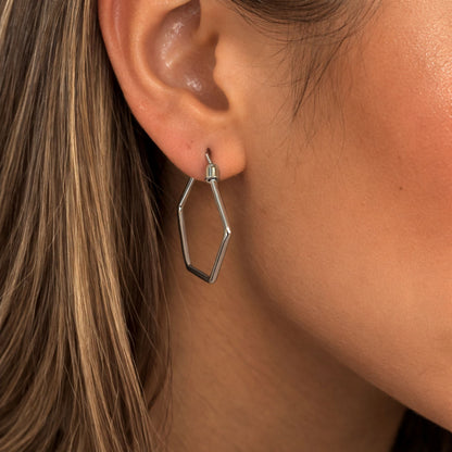 Close-up of a person wearing a geometric silver earring.