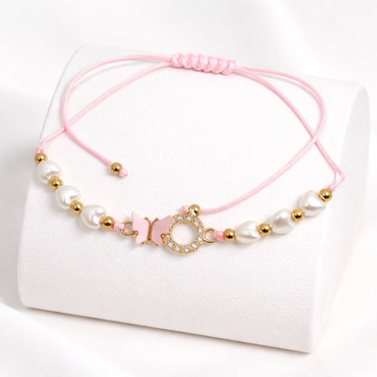 Pink bracelet with pearls and gold beads on a white background