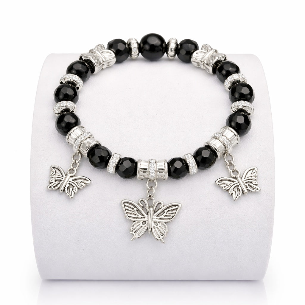 Black beaded bracelet with silver butterfly charms on a white stand