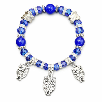 Blue beaded bracelet with owl charms on a white background