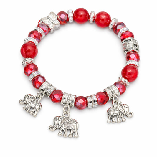 Bracelet with red beads and silver elephant charms on a white background