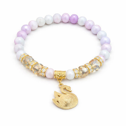 Bracelet with purple and white beads and a gold swan charm on a white background