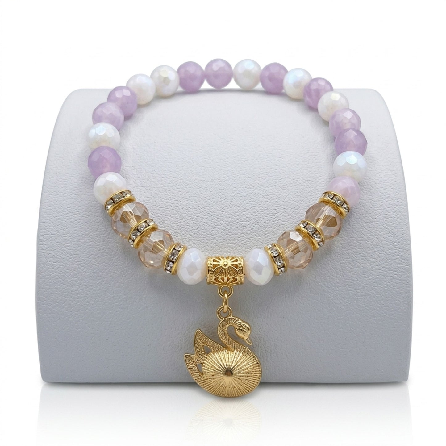 Beaded bracelet with a gold swan charm on a white stand