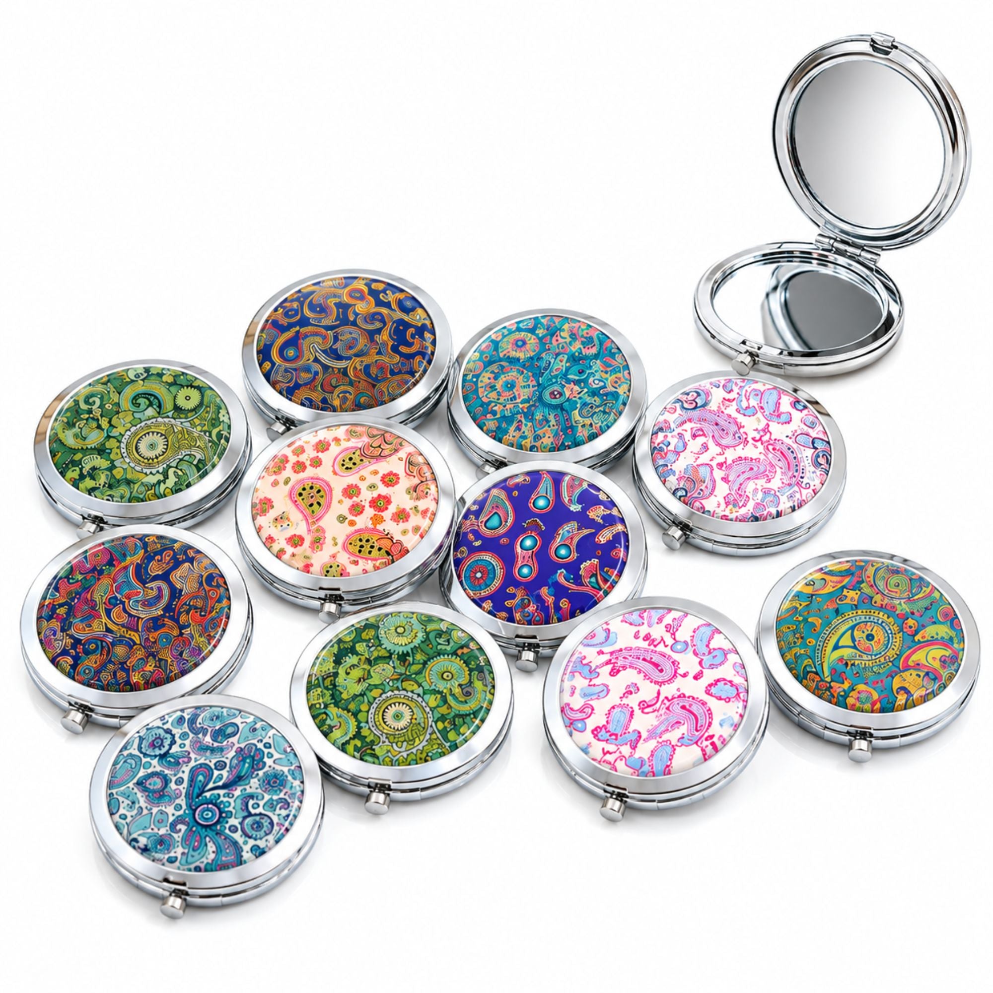 A set of round silver compact mirrors with colorful paisley patterns, with one compact open to show the mirror interior, on a white background.