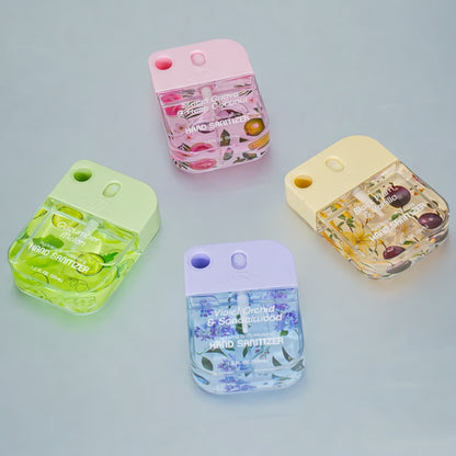 Four hand sanitizer bottles with floral designs on a light gray background