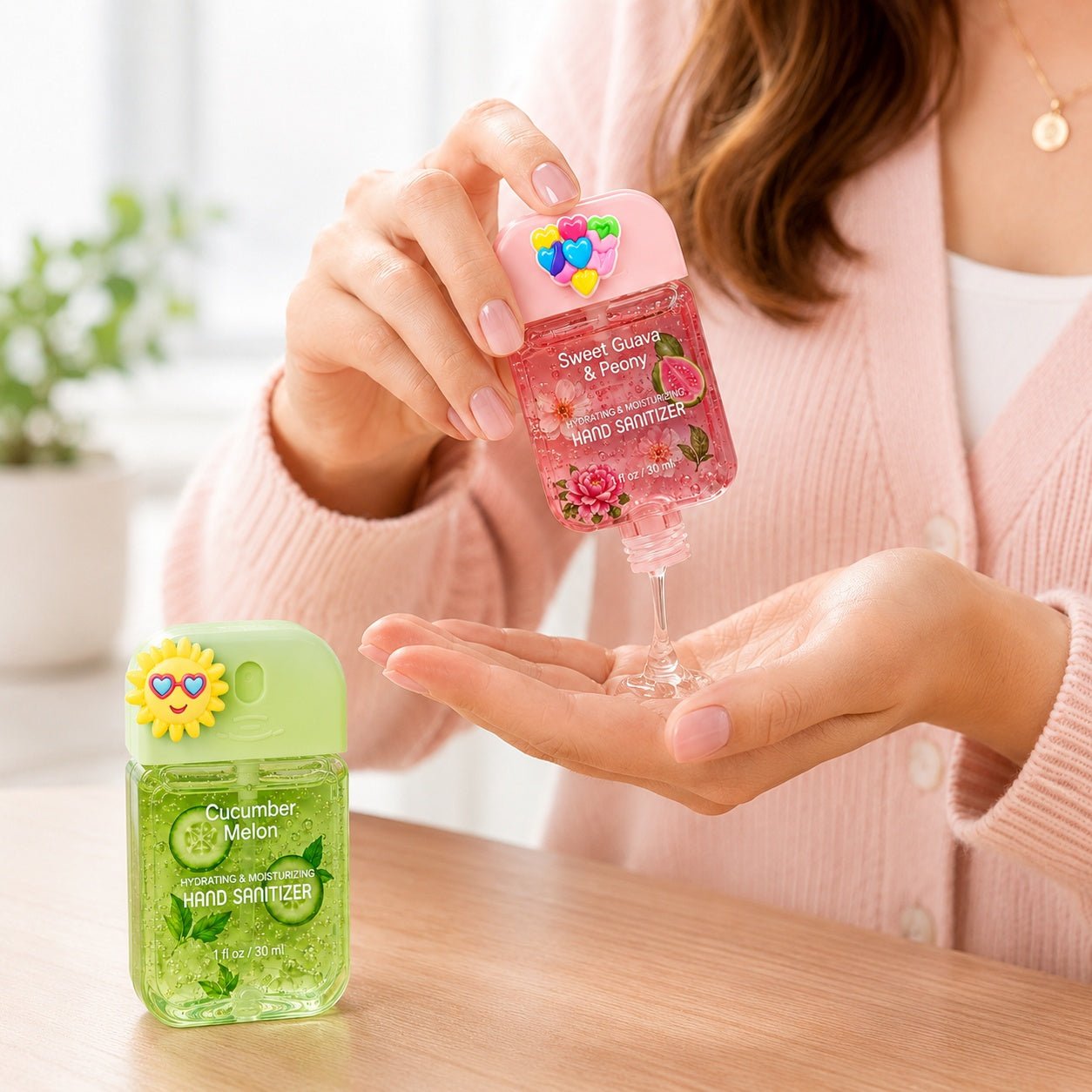 Person holding a pink hand sanitizer bottle with colorful design, next to a green bottle labeled 'Cucumber Melon'.