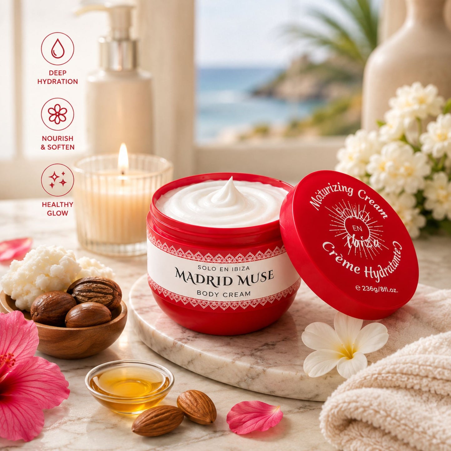 A red jar of Madrid Muse body cream with white cream inside, shown open on a marble tray with the lid beside it. The scene includes skincare props such as a candle, flowers, almonds, and a small bowl of honey, with a softly blurred beach-and-candlelit background.