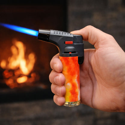Using Blink 4.5-inch tie dye torch lighter with blue jet flame in front of a fireplace.
