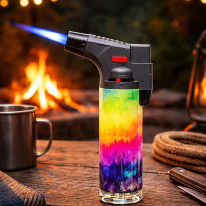 Blink 4.5-inch tie dye torch lighter with blue jet flame in front of a fireplace.