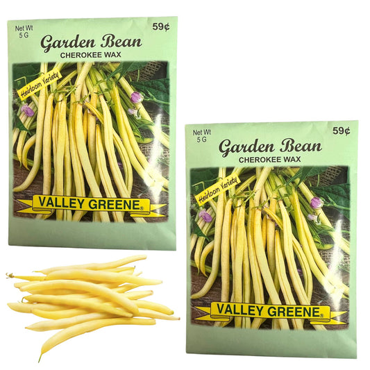 Two packages of Valley Greene Cherokee Wax garden bean seeds with a small pile of yellow beans below.