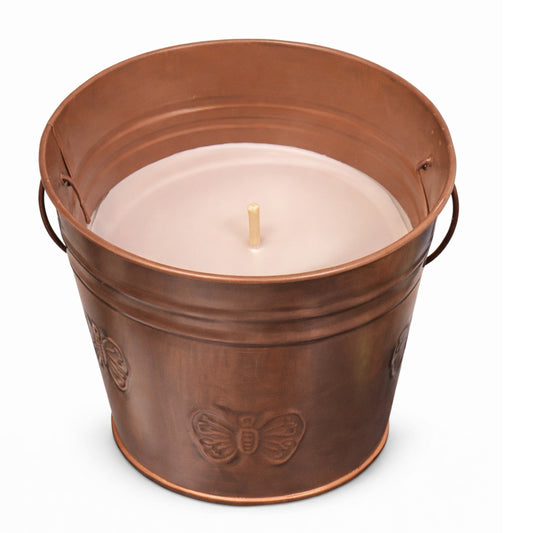 Copper bucket with a lit candle inside on a white background