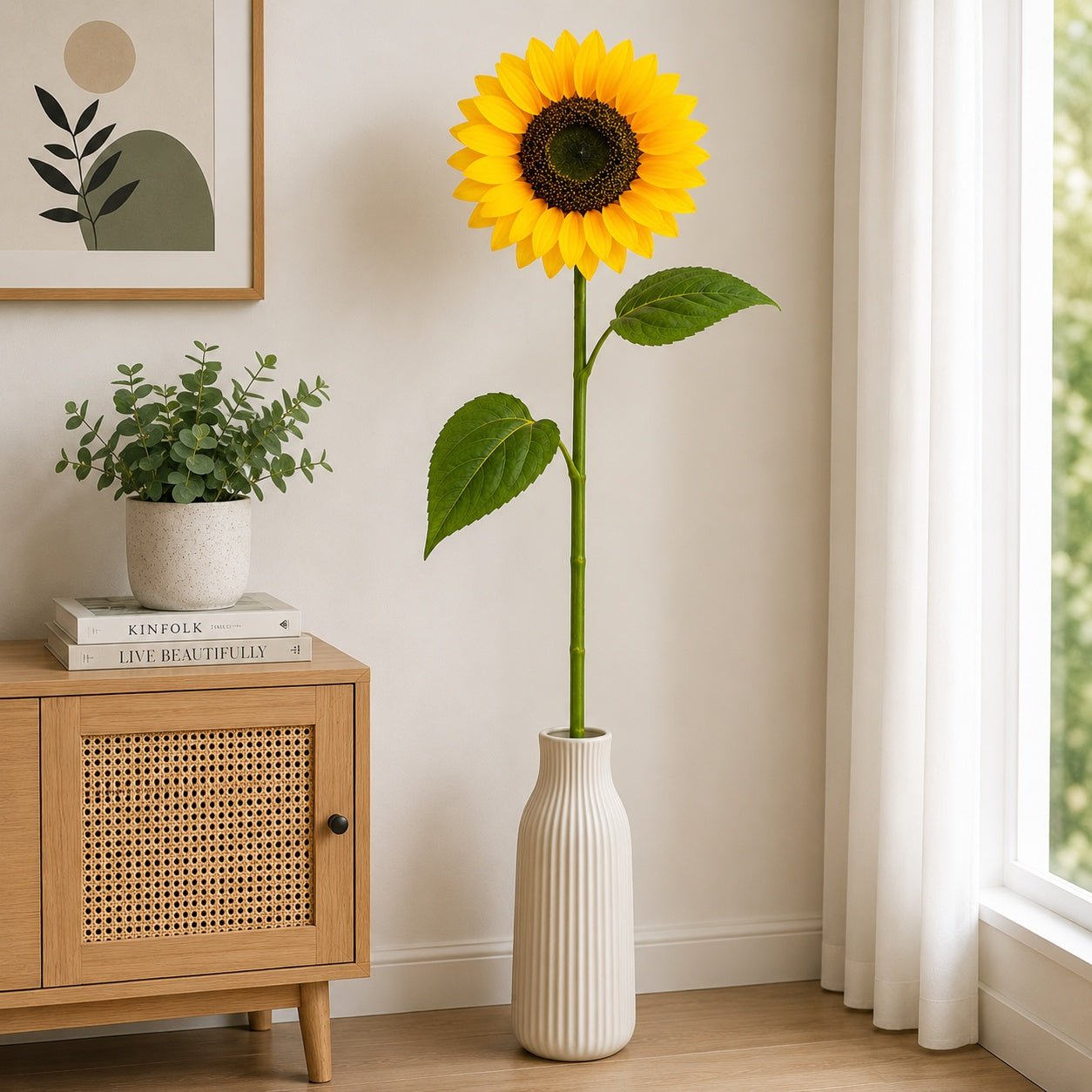 Sunflower in a white vase on a wooden cabinet with a plant and books in a bright room.