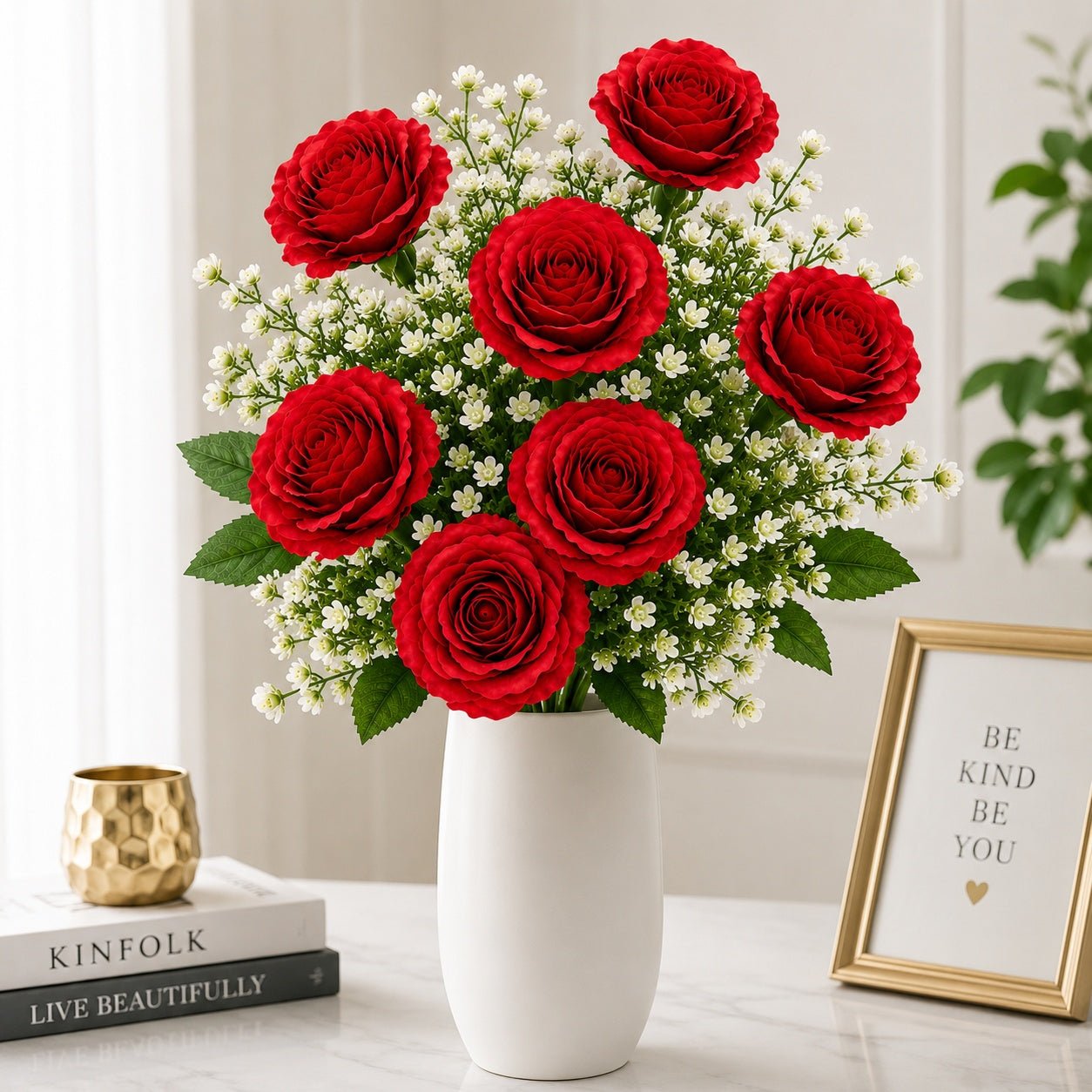 Bouquet of red roses with small white flowers in a white vase on a table.
