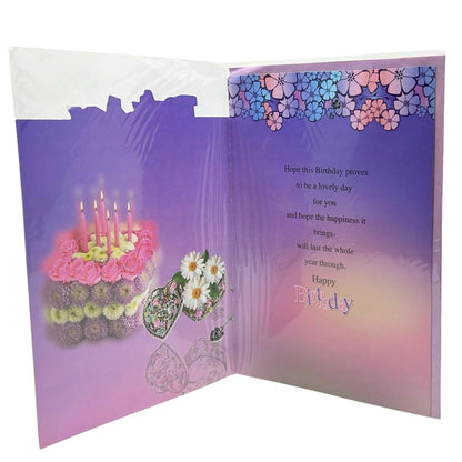 Open birthday card with cake and flowers illustration on one side and floral border and message on the other, on a white background.