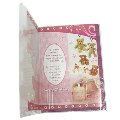 Pink birthday card with teddy bears and a candle, partially open, on a white background.