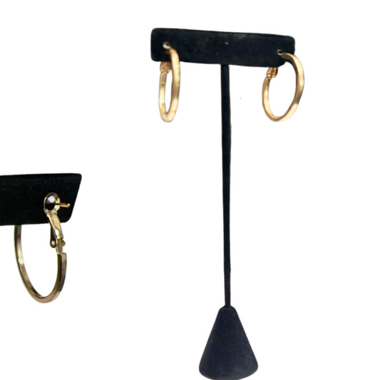 Gold hoop earrings on a black earring stand against a white background