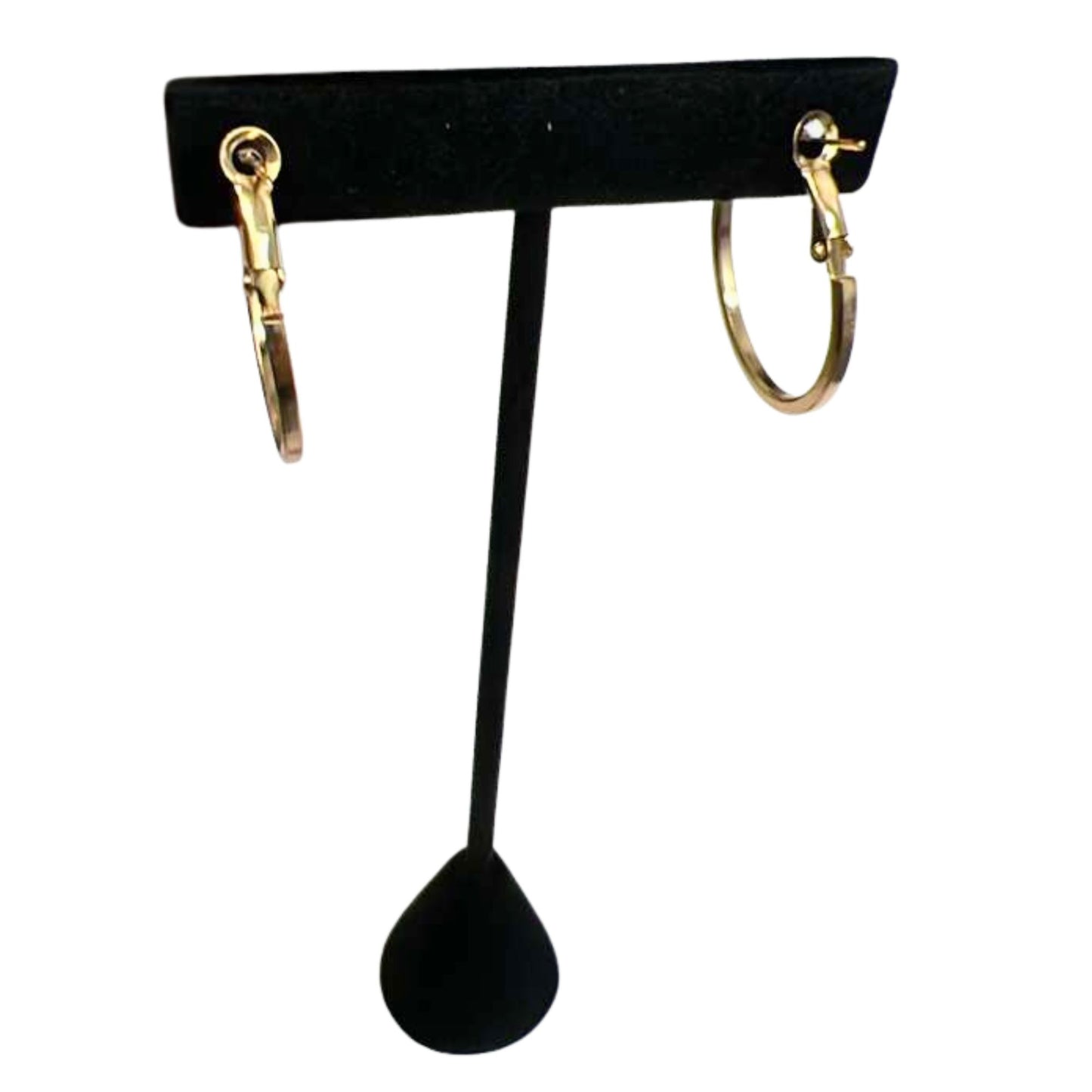 Gold hoop earrings on a black earring stand against a white background