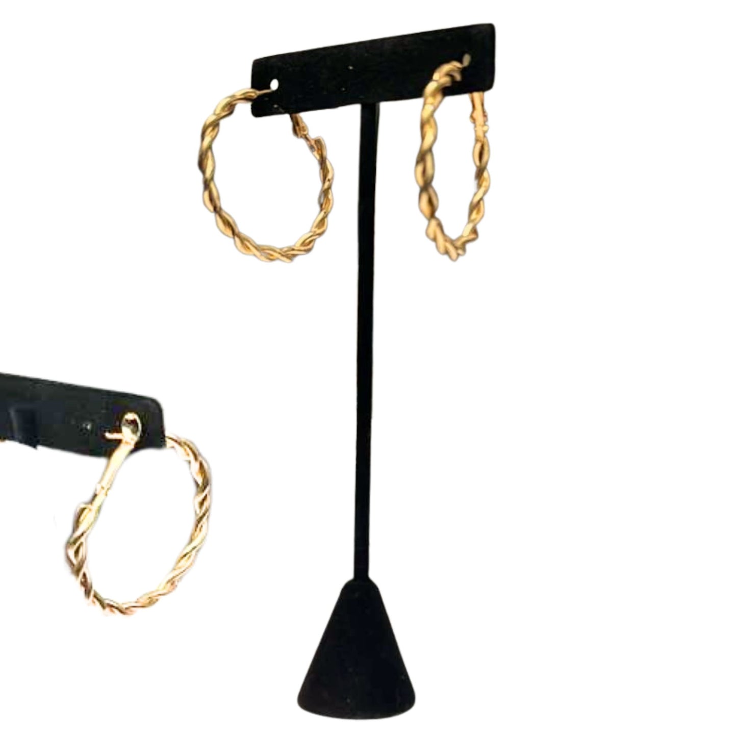 Gold hoop earrings on a black earring stand against a white background