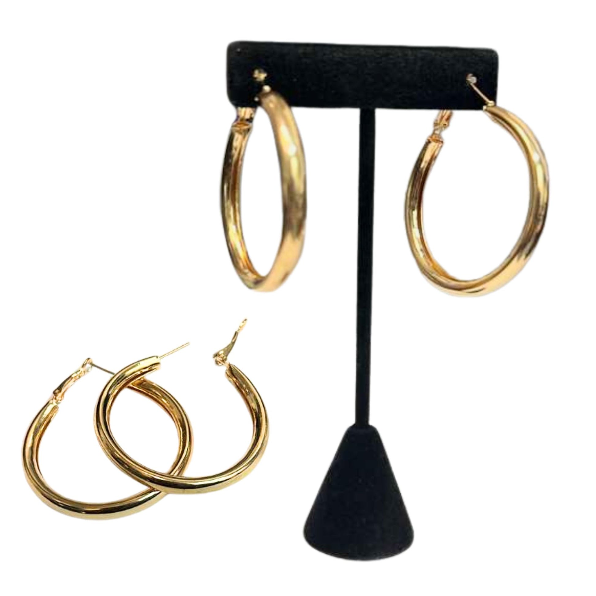 Gold hoop earrings on a black earring stand with additional pairs displayed below.