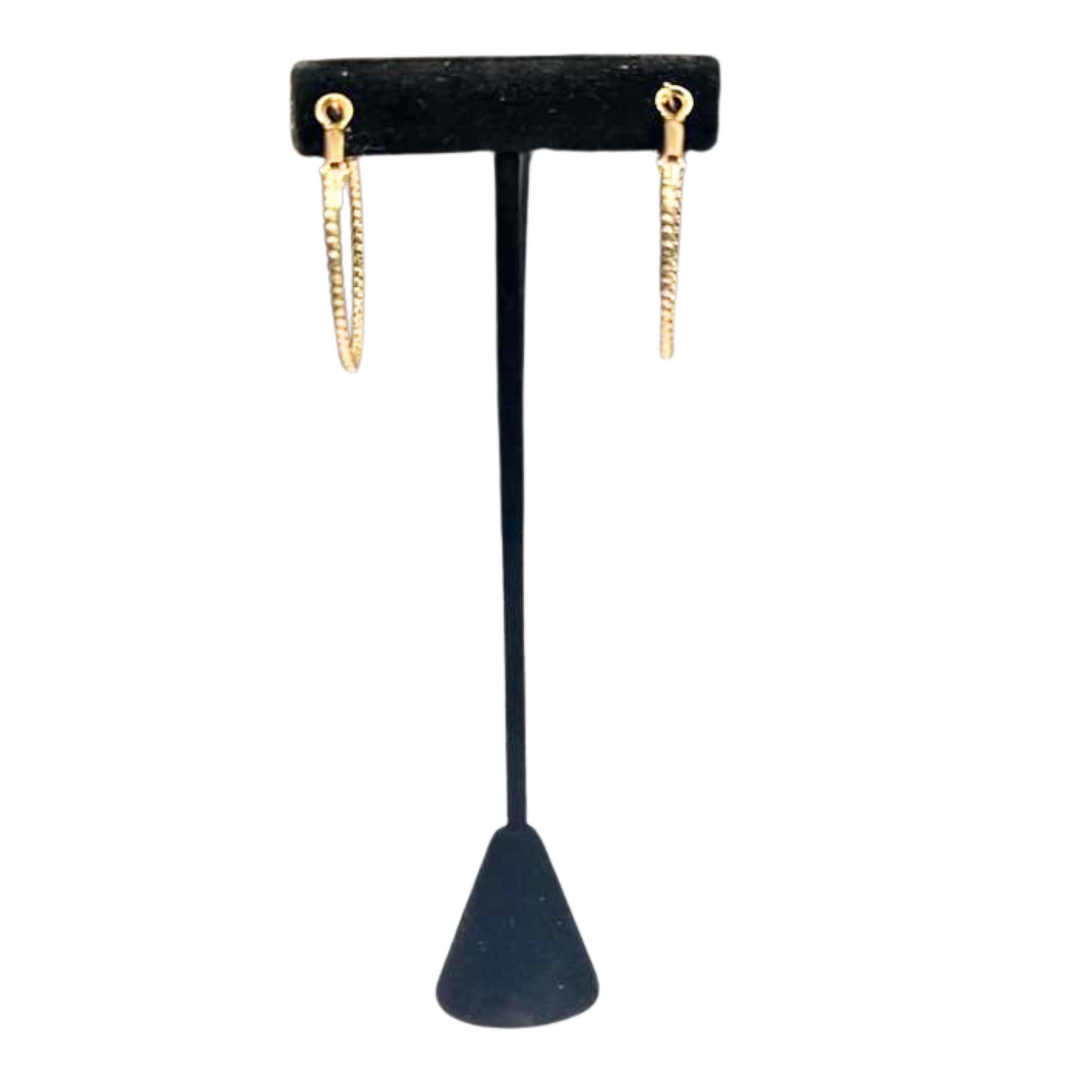 Gold hoop earrings on a black earring stand against a white background