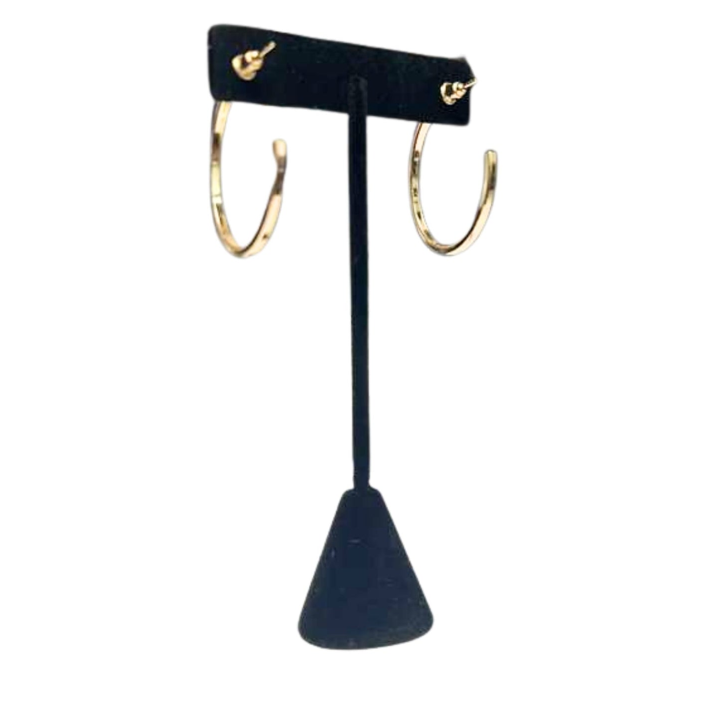 Gold hoop earrings on a black earring stand against a white background