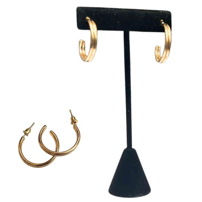 Gold hoop earrings on a black earring stand with additional earrings displayed below.