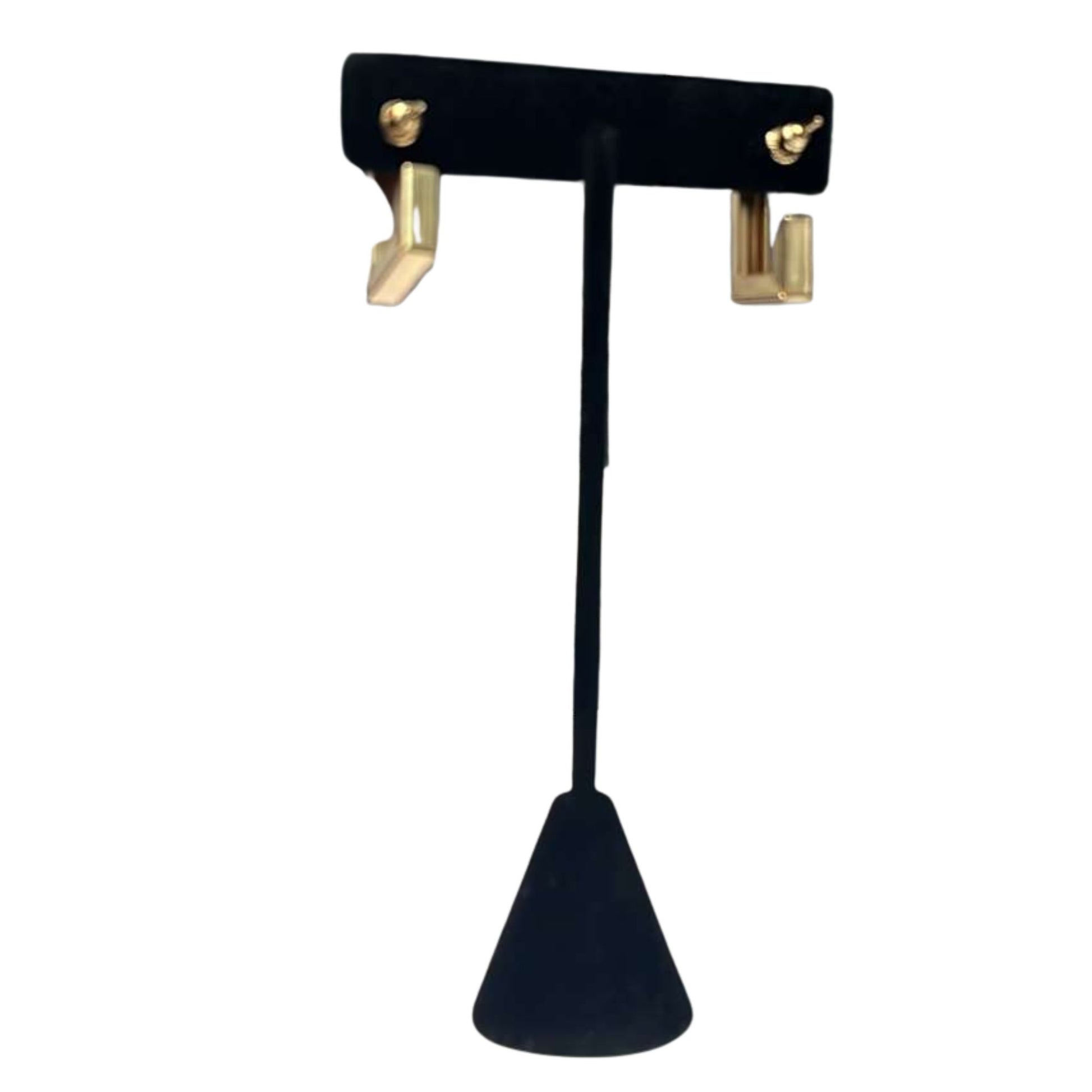 Black earring stand with gold hooks on a white background