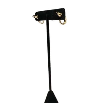 Black earring stand with gold hooks on a white background