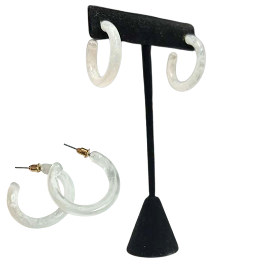 White hoop earrings on a black earring stand with additional earrings displayed.