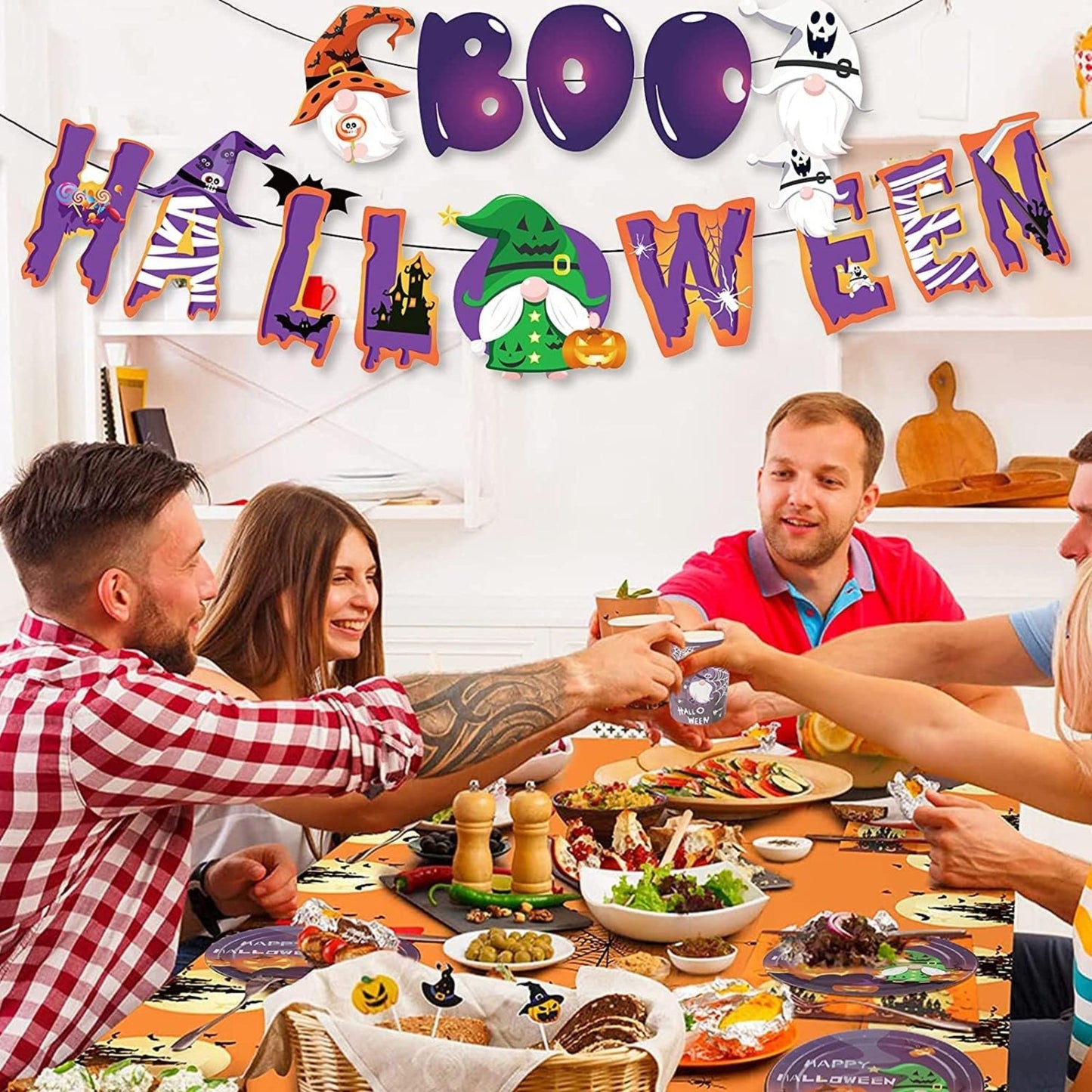 Group of people celebrating Halloween with a decorated room and festive table setting.