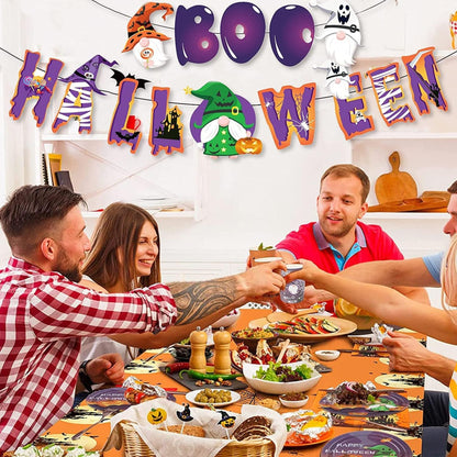 Group of people celebrating Halloween with a decorated room and festive table setting.