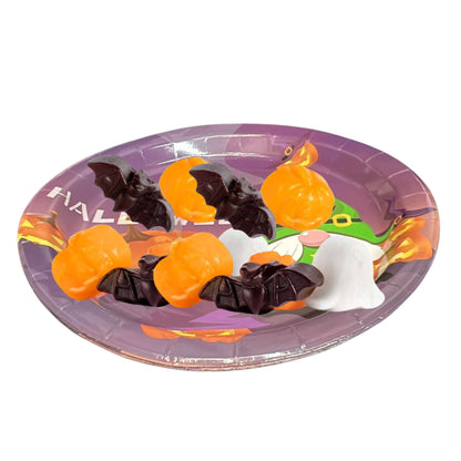 Halloween-themed paper plate with candy pieces on a white background