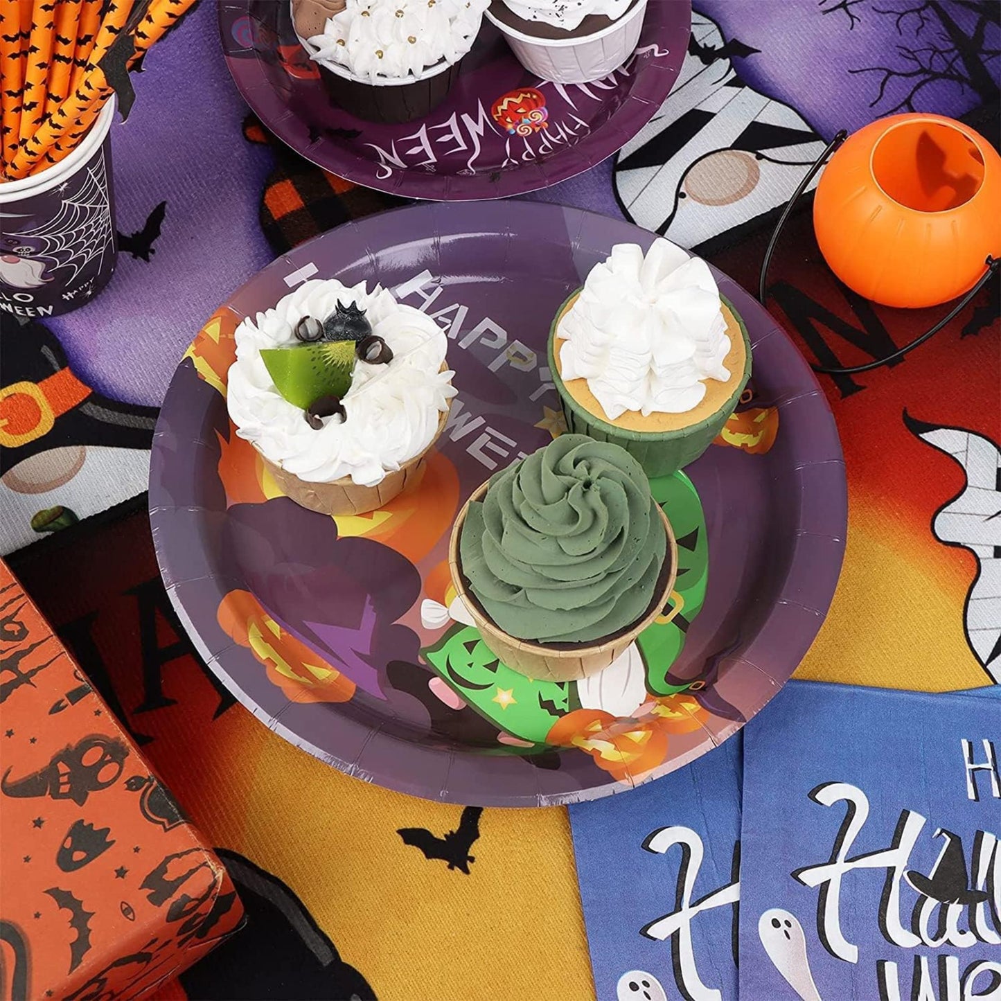 Halloween-themed cupcakes on a decorative plate with festive tableware.