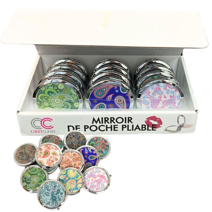Set of compact mirrors with colorful designs in a display box, featuring the brand 'Cindy Claire'.
