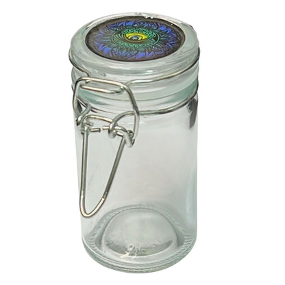 Clear glass jar with a decorative metal lid on a white background