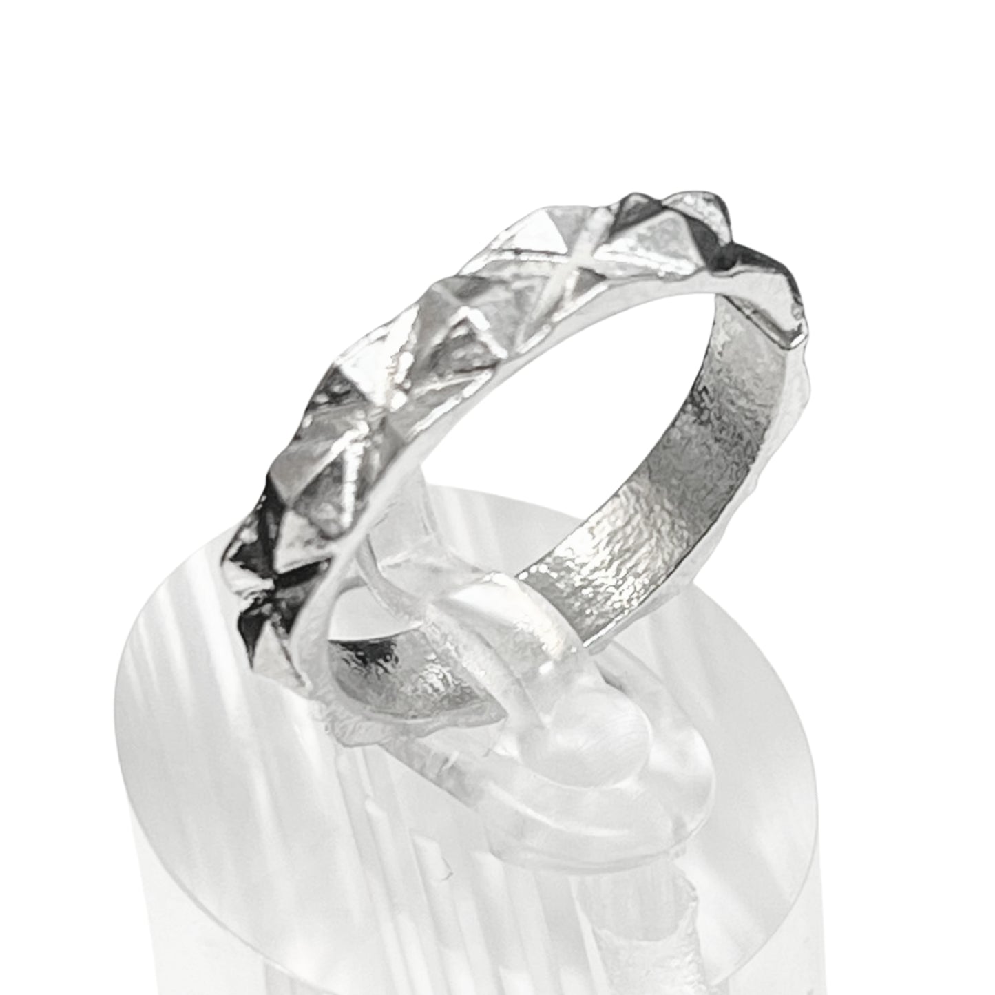 Silver ring with a textured band on a white background
