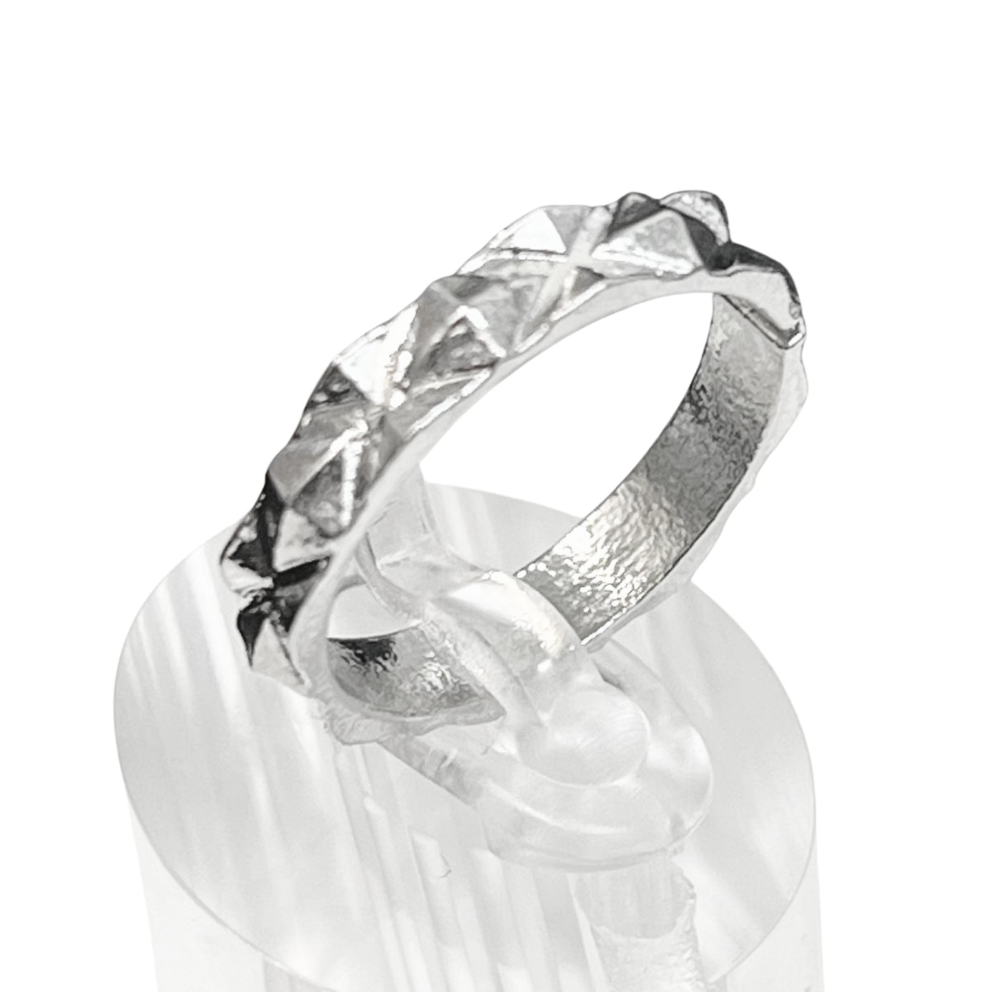 Silver ring with a textured band on a white background