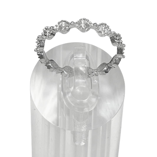 Silver ring with gemstones on a clear stand against a white background