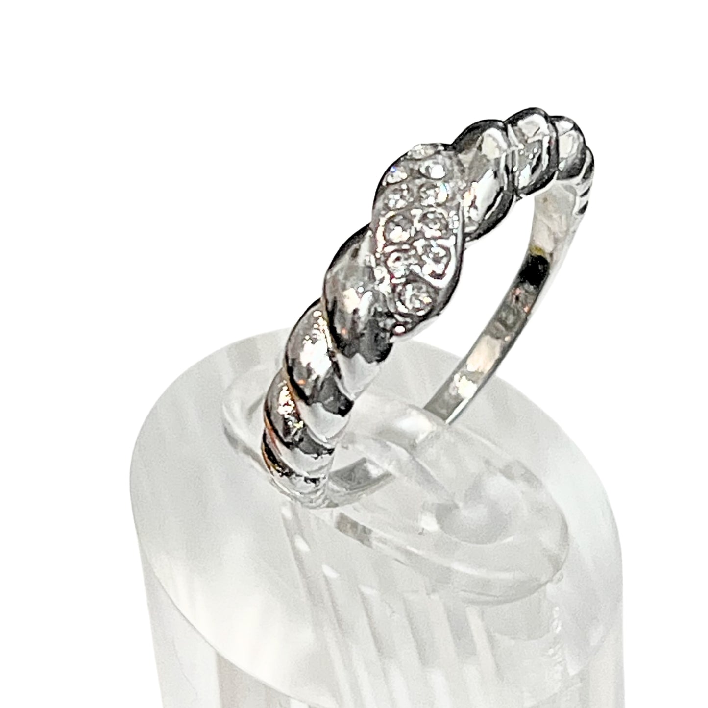 Silver ring with diamond accents on a clear stand against a white background